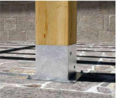Base metálica para fijación de postes de madera en suelos de hormigón, proporcionando estabilidad y resistencia en estructuras exteriores.